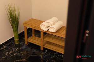 Duas toalhas numa mesa de madeira na casa de banho em Apartment Eden em Požega
