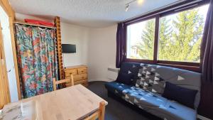 ein Wohnzimmer mit einem Sofa und einem Tisch in der Unterkunft Le 3300 - 42 - Studio vue piste - 2 pers in Les Deux Alpes