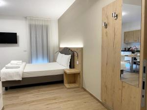 a small bedroom with a bed and a kitchen at Bernina Suite in Tirano