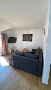 een woonkamer met een blauwe bank en een tafel bij Marina in Sesvete