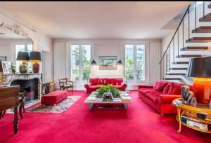 a living room with a red couch and a fireplace at 4 bedroom Luxury Eiffel Tower Apartment in Paris