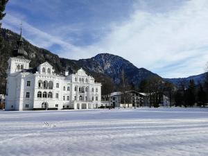a large white building with snow in front of it at Schloss Grubhof Appartement in Sankt Martin bei Lofer