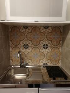 a sink in a kitchen with a tile wall at Schloss Grubhof Appartement in Sankt Martin bei Lofer