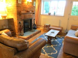 a living room with a couch and a fireplace at Lavender Row Stedham in Midhurst