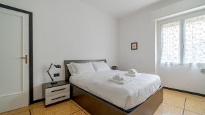 um quarto branco com uma cama e uma janela em Italianway - Betti 46 em Rapallo