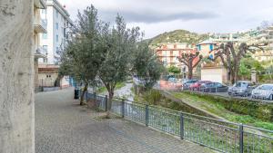 uma passagem com uma cerca, árvores e edifícios em Italianway - Betti 46 em Rapallo