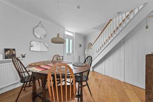 uma sala de jantar com uma mesa e cadeiras e uma escadaria em St John's Corner Cottage, Bury St. Edmunds em Bury Saint Edmunds