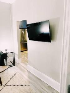 a living room with a flat screen tv on a wall at The LOCAL BREW Perfect For FOODIES BEER LOVERS in Fredericton