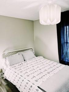 sypialnia z białym łóżkiem i żyrandolem w obiekcie The LOCAL BREW Perfect For FOODIES BEER LOVERS w mieście Fredericton