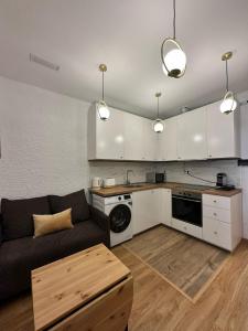 ein Wohnzimmer mit Couch und Küche in der Unterkunft MI CASA ES TU CASA in Hospitalet de Llobregat