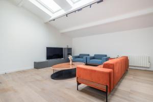 a living room with a couch and a table and a tv at Chaleureux appartement6personnes in Asnières-sur-Seine