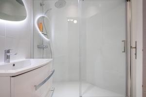 a white bathroom with a sink and a shower at Chaleureux appartement6personnes in Asnières-sur-Seine