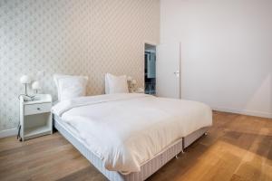 a bedroom with a large white bed and a mirror at Chaleureux appartement6personnes in Asnières-sur-Seine