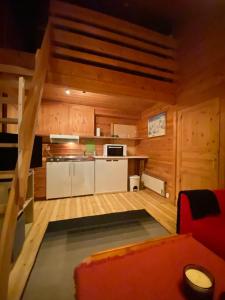 una cocina en una cabaña de madera con un sofá rojo en Kvamskogen & Hardanger Holliday homes en Norheimsund