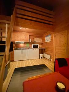 a kitchen in a log cabin with a red couch at Kvamskogen & Hardanger Holliday homes in Norheimsund +44 photos