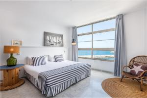 a bedroom with a bed and a large window at Marina Suites Gran Canaria in Puerto Rico de Gran Canaria