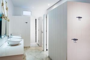 a white bathroom with a toilet and a sink at Marina Suites Gran Canaria in Puerto Rico de Gran Canaria