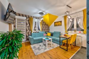 a living room with a blue couch and a table at SkyLine Lux 2 Apartman Zlatibor in Zlatibor