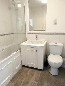a white bathroom with a toilet and a sink at Spacious Quiet Stylish entire flat in London