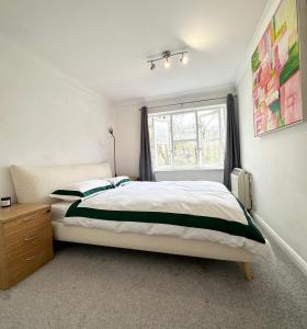 a bedroom with a large bed and a window at Spacious Quiet Stylish entire flat in London