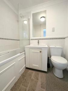 a bathroom with a toilet and a sink and a mirror at Spacious Quiet Stylish entire flat in London