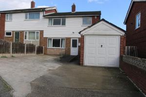 a white garage door in a brick house at Comfy 2-Bedroom House in Parkgate - Ideal for Contractors/Business Travellers in Rotherham