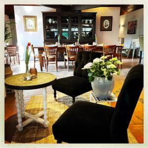 a living room with chairs and a table with a vase of flowers at Boslodge XL in Alphen