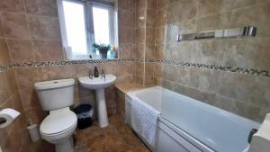 a bathroom with a toilet and a sink and a tub at New - Modern Home from Home, 3 bedrooms, 2.5 bath in Plymouth