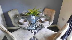 a glass table with two chairs and a glass table with cups at New - Modern Home from Home, 3 bedrooms, 2.5 bath in Plymouth