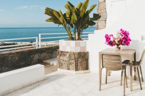un tavolo e sedie su un balcone con vista sull'oceano di Marina Bayview Gran Canaria - Adults Only a Puerto Rico de Gran Canaria