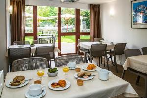 a dining room with a table with plates of food at Appart Hotel Corte HR in Corte