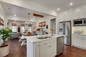 a kitchen with white cabinets and a kitchen island with a sink at The SoFay Farmhouse- 1 MI From U of A in Fayetteville
