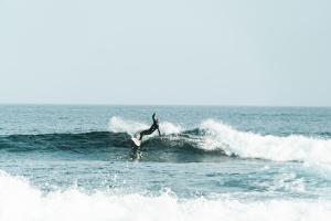 a person riding a wave on a surfboard in the ocean at Buendía Corralejo Nohotel in Corralejo
