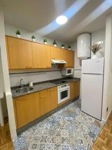 a kitchen with wooden cabinets and a white refrigerator at Apartamento El Rinconín in Cangas de Onís +5 photos