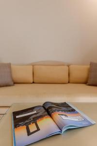 a book on a coffee table in front of a couch at Aegean Palace in Plaka