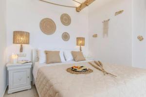 a white bedroom with a bed with a plate of food on it at Glaronissi Beach in Plaka