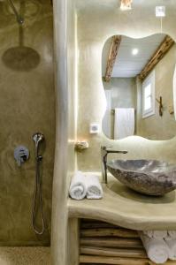 W łazience znajduje się kamienna umywalka i lustro. w obiekcie Glaronissi Beach w mieście Plaka