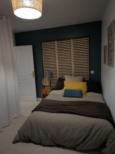 - une chambre avec un grand lit et des oreillers jaunes dans l'établissement Maison en Baie Du Mont, à Roz-sur-Couesnon