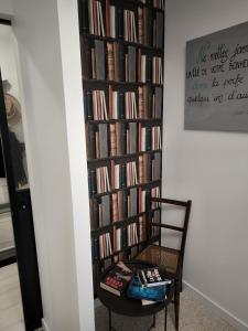 une étagère remplie de livres à côté d'une chaise dans l'établissement Maison en Baie Du Mont, à Roz-sur-Couesnon