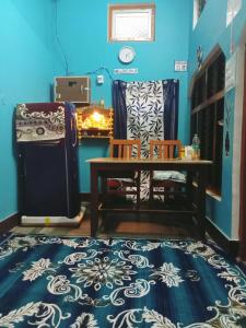 a room with a table and two chairs on a blue wall at Hari Suman Paying Guest house in Ayodhya