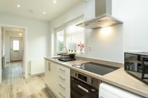 a kitchen with a sink and a stove at Heath House in Burton upon Trent
