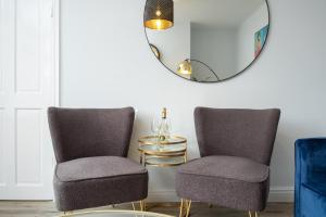 a room with two chairs and a mirror at Heath House in Burton upon Trent