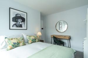 1 dormitorio con cama con espejo y escritorio en Heath House en Burton upon Trent
