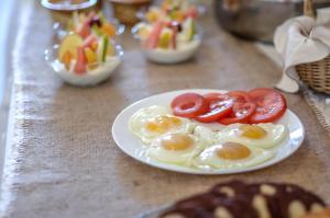 un plato de huevos y tomates en una mesa en Glaronissi Beach, en Plaka
