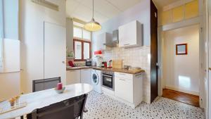 een keuken met witte apparatuur en een tafel bij Authentic apartment in the heart of Vevey in Vevey