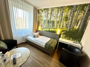 Habitación pequeña con cama y ventana con árboles en Hotel "Central" Inh Carolin Krause, en Bitterfeld