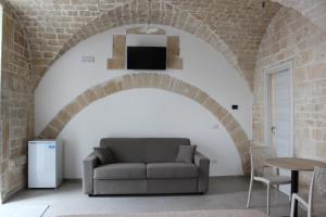 a living room with a couch in a brick wall at b&b Olio su Pietra in Castellana Grotte