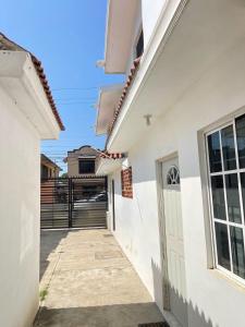 einen Gang zwischen zwei weißen Gebäuden mit einem Tor in der Unterkunft Apartamentos Tampico-Altamira 
