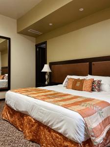 アラフエラにあるHotel 1915 INN & SUITESのベッドルーム1室(大型ベッド1台、大型ヘッドボード付)