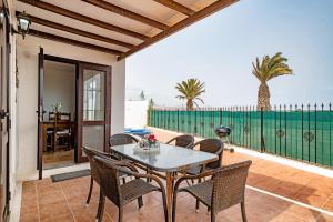 a dining room with a table and chairs on a patio at Villa Kanak in Puerto del Carmen